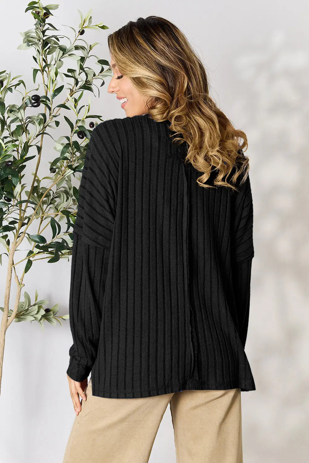 Trendsi black ribbed knit long sleeve sweater worn by woman posing indoors
