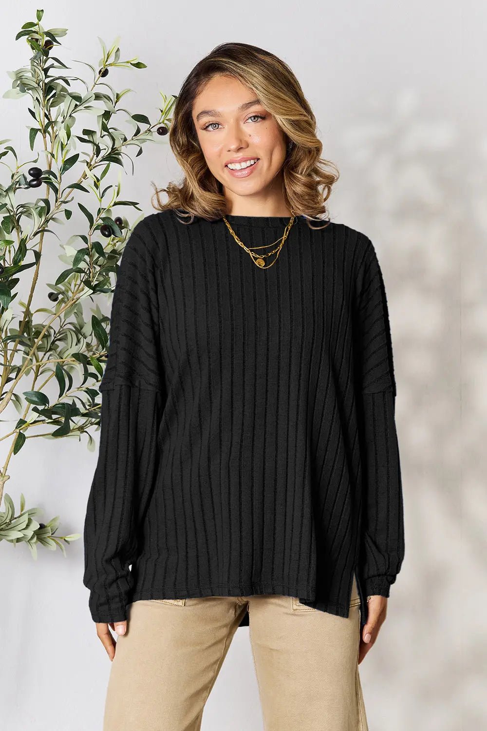 Trendsi black ribbed knit sweater with long sleeves worn by smiling woman with necklace