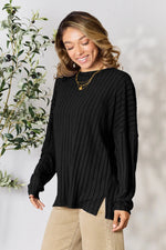Trendsi black ribbed knit sweater with long sleeves and side slits worn by smiling woman