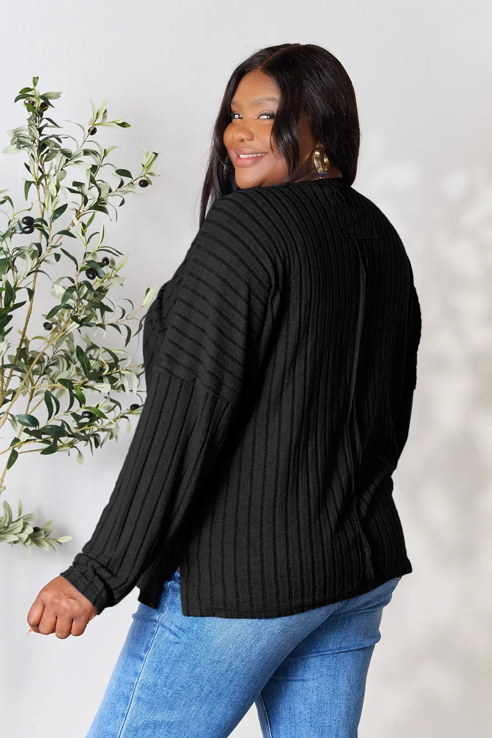 Trendsi black ribbed knit long sleeve top worn by woman paired with blue jeans
