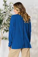 Trendsi blue ribbed knit long sleeve top worn by woman with beige pants back view